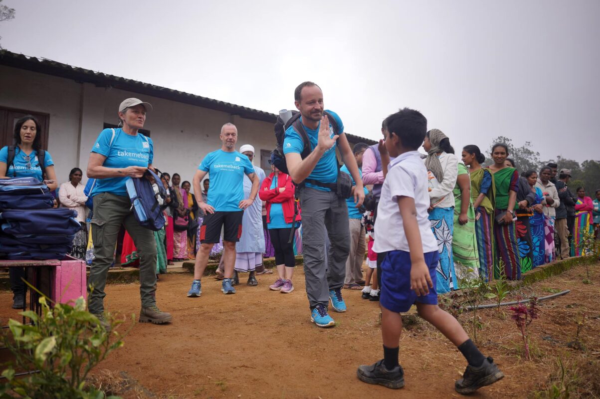 Rappresentante di Gruppo Xera dà il cinque a un bambino nero durante la missione di solidarietà in Sri Lanka con l'organizzazione no-profit Take Me Back