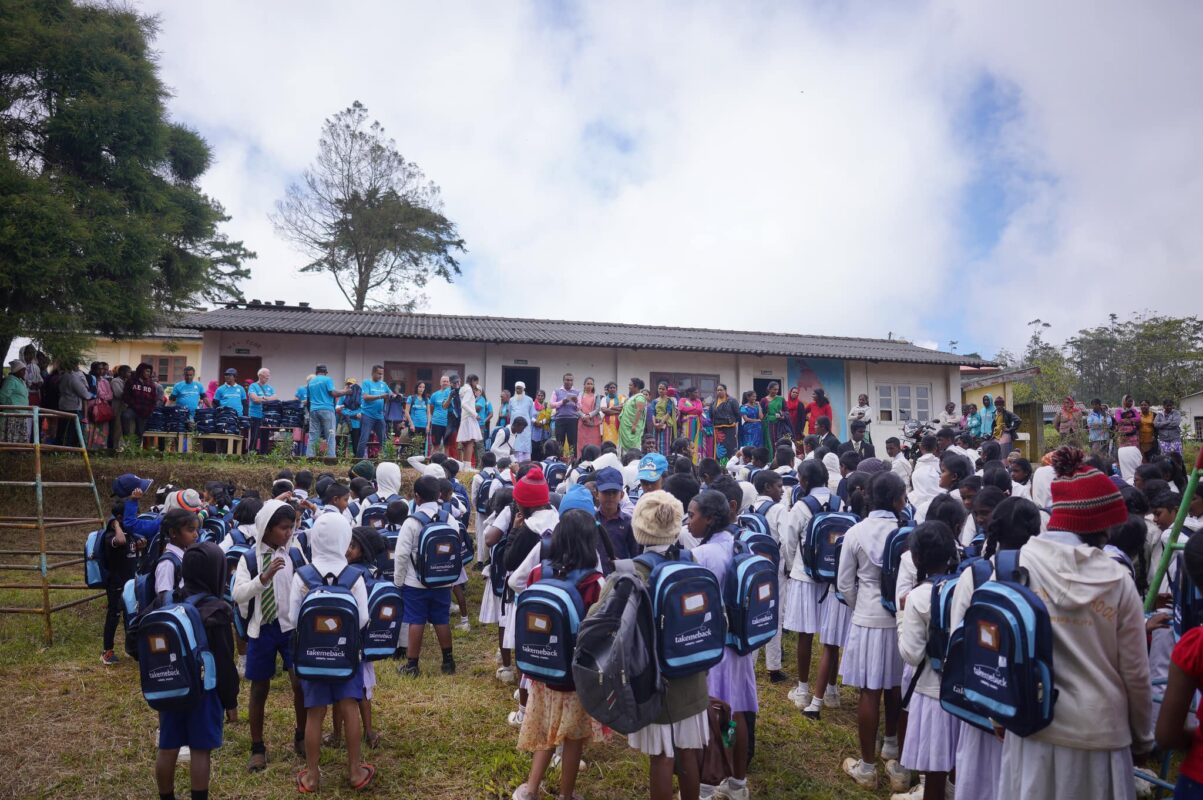Bambini di una scuola dello Sri Lanka ricevono dagli operatori dell'organizzazione no-profit Take Me Back zaini personalizzati, distribuiti durante la missione di solidarietà in Sri Lanka, sostenuta dal Gruppo Xera.