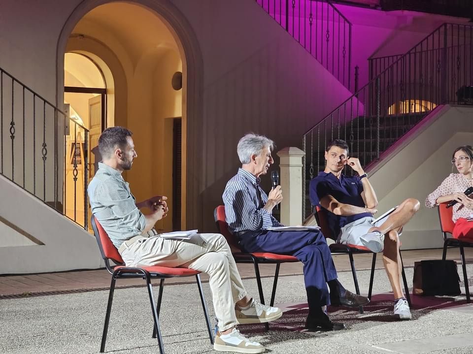 Esperto di cybersecurity durante conferenza su sicurezza informatica, parla al pubblico con microfono