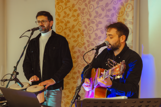 Due musicisti cantano e suonano strumenti musicali